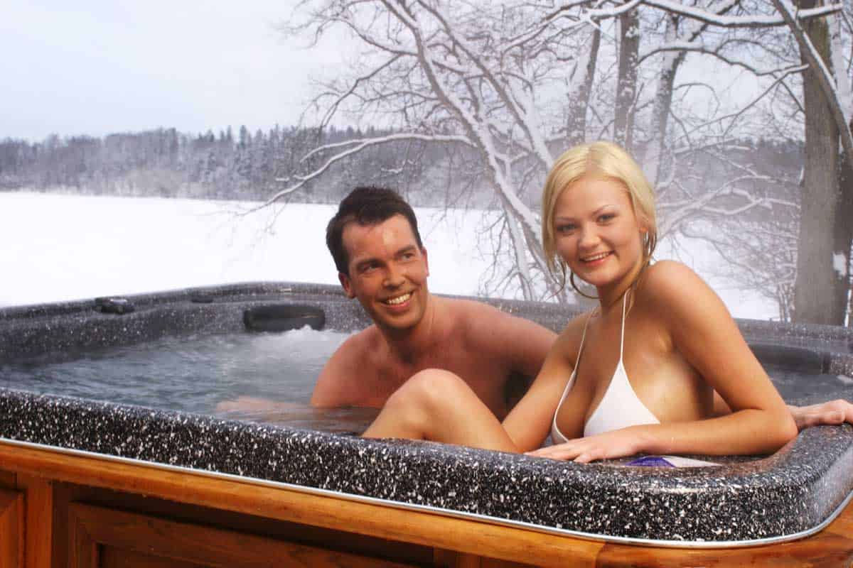 A couple in a hot tub in winter